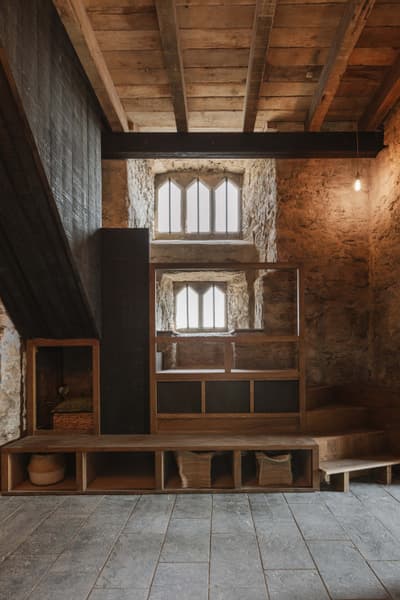 Architectural project - exposed stone, unique windows, heritage design, stone walls, rustic interior, vintage style, grey tiles, traditional elements, historic building, aged wood, medieval style, wooden shelving, Scandinavian influences, intimate space, wood, timber, natural light, cottage feel, sustainable design, reclaimed materials, grey, neutral tones, beige, brown, compact space, wooden beams, natural textures, rustic charm, cozy retreat, multifunctional, modern rustic, cozy vibe, stone, small window, timber ceiling, earthy tones, warm atmosphere, handcrafted look, eco friendly space, artisanal design, stone flooring, slate floor, wood ceiling, residential use, warm lighting, built-in storage, timber finish, stone texture