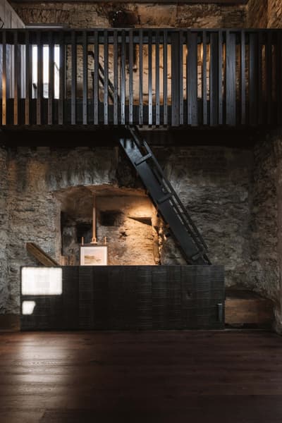 Architectural project - raw finishes, exposed materials, loft style, exposed stone, creative studio, modern renovation, artistic vibe, rugged texture, rustic interior, atmospheric, historic building, vintage charm, dramatic lighting, art display, intimate space, wood, timber, eclectic style, brown, contemporary touch, minimalist design, black, industrial chic, stone, textured wood, inviting space, earthy tones, stone wall, cozy atmosphere, heritage building, open space, minimal decor, timber railing, warm lighting, architectural contrast, dark wood, high ceiling, double height
