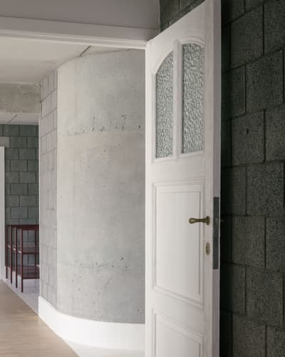 Architectural project - passageway, exposed materials, simple aesthetic, urban aesthetic, light wood floor, block wall, interior detail, white door, vintage handle, privacy, structured look, contemporary vibes, subtle contrast, refined elegance, structural expression, understated design, privacy design, design contrast, texture, block, architectural detail, grey tones, raw materials, grey, neutral tones, concrete, industrial style, modern design, architectural texture, neutral palette, construction detail, clean lines, white, textured wall, minimalist space, modern home, sleek design, calm atmosphere, clean design, hallway, concrete wall, minimalist interior, residential interior, urban style, entryway
