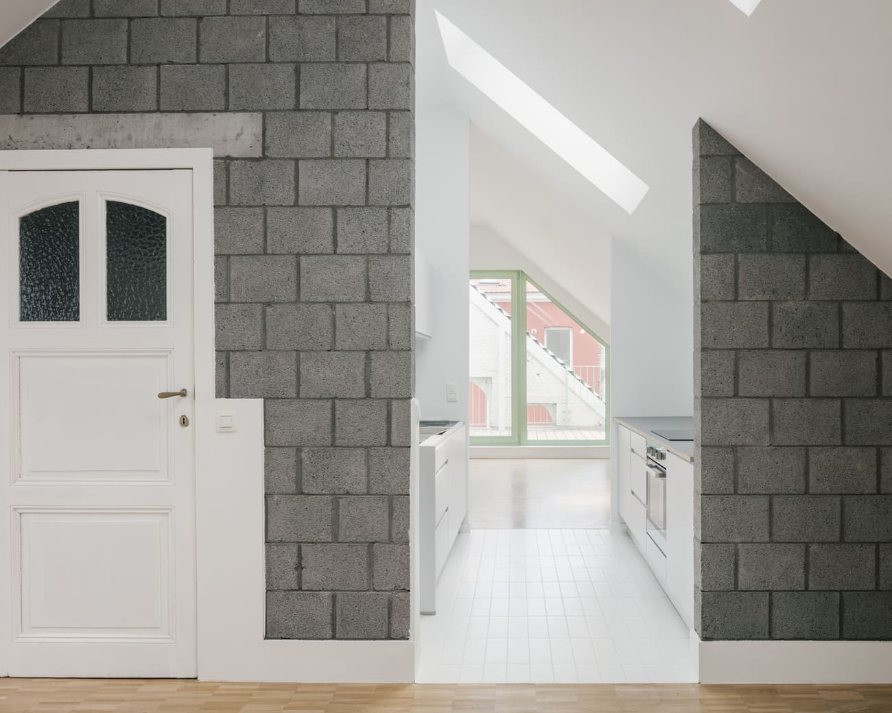 Architectural project - urban dwelling, skylights, attic kitchen, white kitchen, light wood floor, concrete block, exposed block, grey kitchen, loft living, modern finishes, parquet floor, airy vibe, city loft, bright white, streamlined kitchen, sleek surfaces, home refurbishment, city living, natural light, sustainable design, recycled materials, contemporary style, grey, neutral tones, ventilation, functional space, light wood, compact space, simple design, minimalist vibe, serene atmosphere, Scandinavian style, eco-friendly materials, geometric design, low carbon, passive house, clean lines, white, Nordic design, textured wall, energy efficient, open plan, green home, bright interior, energy saving, minimalist kitchen, modern kitchen, efficient layout, modern living, eco renovation, urban apartment, urban vibe, kitchen renovation