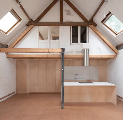 Architectural project - plywood walls, skylights, attic renovation, loft conversion, renovation project, multipurpose space, warm floor, architectural detail, sustainable materials, natural light, passive design, sustainable design, neutral tones, exposed beams, daylight, beige, brown, truss structure, light wood, timber beams, rustic modern, industrial touch, Scandinavian style, minimalist design, wood floor, wood panels, modern rustic, clean lines, white, Nordic design, eco friendly home, small space, warm ambiance, open plan, earthy tones, bright interior, functional layout, kitchen island, compact kitchen, plaster walls, modern living, cozy home, eco renovation, vaulted ceiling