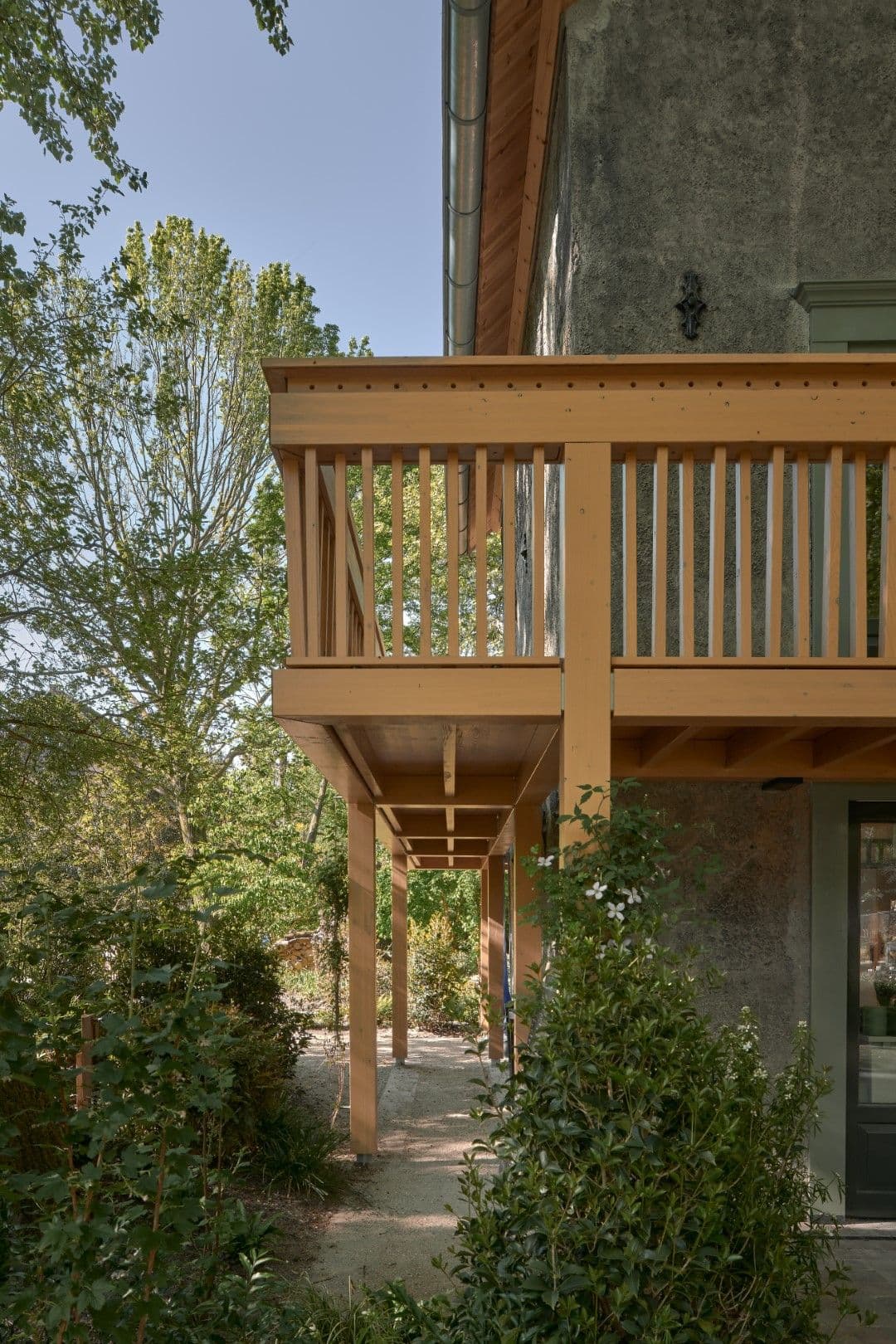 Architectural project - nature vibes, exterior facade, countryside charm, plant-filled, timber posts, relaxing atmosphere, peaceful space, backyard view, outdoor facade, natural materials, serene environment, raw materials, natural light, outdoor living, warm tones, eco design, exposed structure, neutral tones, daylight, light wood, natural wood, eco friendly, rural architecture, honey wood, green architecture, sustainable home, countryside home, textured wall, plaster wall, rustic style, earthy tones, garden view, green design, open air, countryside living, rustic home, inviting exterior, warm exterior, outdoor deck, lush greenery, foliage, cozy home, timber railing, soft colors, architectural harmony, connection to nature