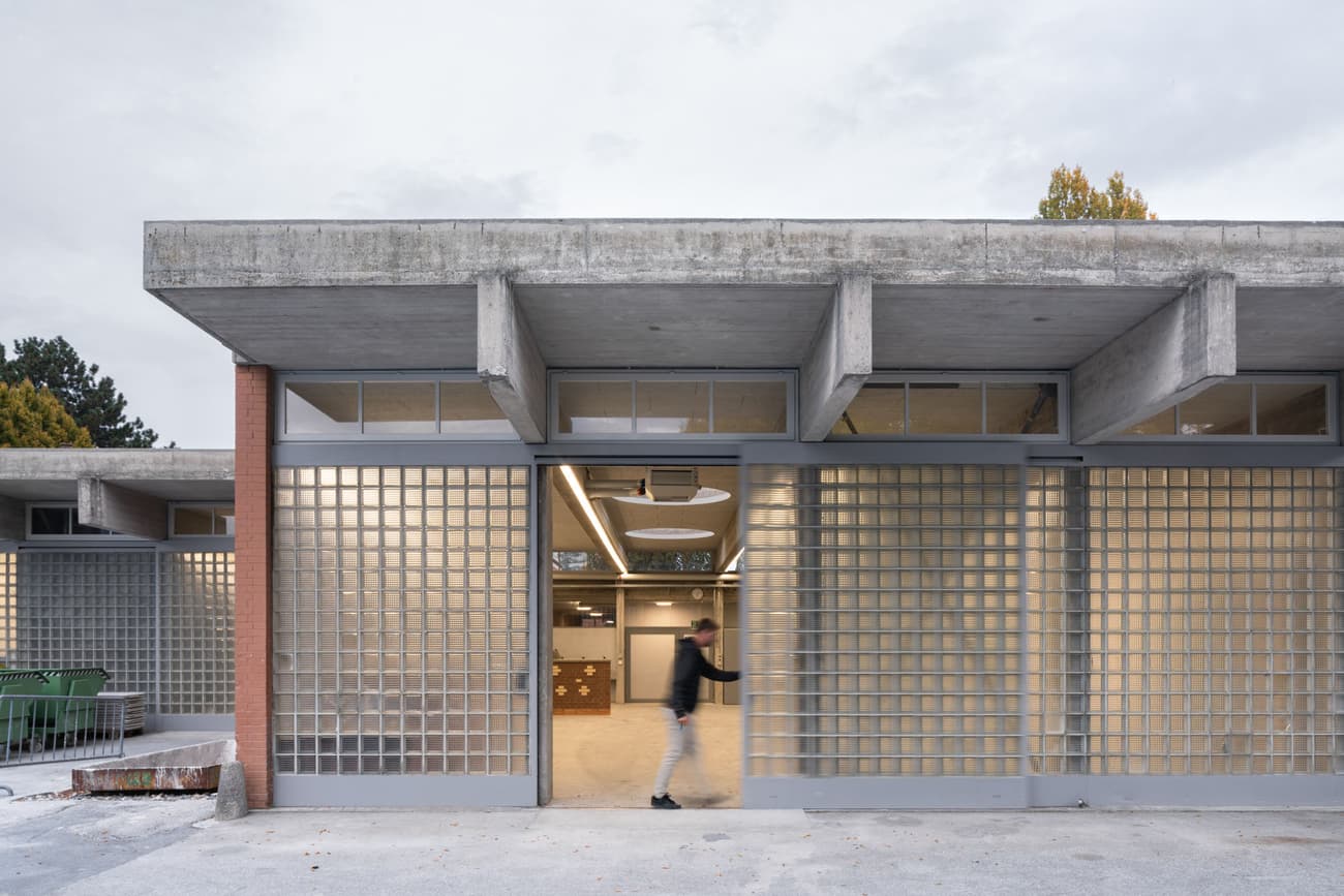 Architectural project - exposed concrete, flexible layout, modern renovation, concrete facade, industrial materials, glass blocks, brutalist style, open entrance, steel frames, innovative use of materials, architectural detail, eco-friendly design, grey tones, steel, cityscape, outdoor space, natural light, glass, sustainable architecture, grey, daylight, concrete, functional design, neutral palette, minimalist design, community hub, urban design, clean aesthetic, adaptable space, industrial chic, durable materials, large windows, indoor outdoor, modern architecture, raw finish, textured facade, simple lines, low carbon building, public building, industrial building, innovative architecture, urban vibe, contemporary building