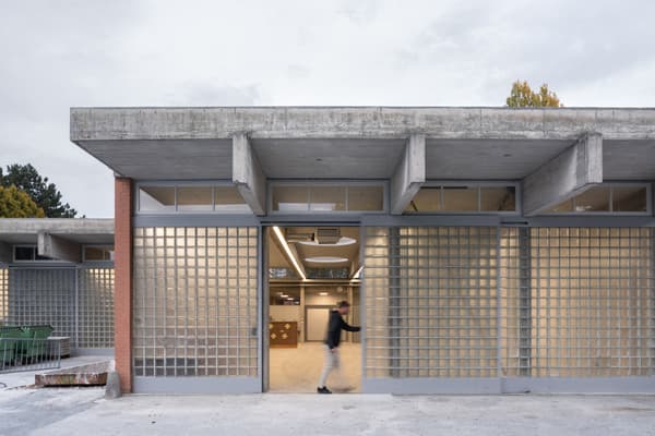 Architectural project - exposed concrete, flexible layout, modern renovation, concrete facade, industrial materials, glass blocks, brutalist style, open entrance, steel frames, innovative use of materials, architectural detail, eco-friendly design, grey tones, steel, cityscape, outdoor space, natural light, glass, sustainable architecture, grey, daylight, concrete, functional design, neutral palette, minimalist design, community hub, urban design, clean aesthetic, adaptable space, industrial chic, durable materials, large windows, indoor outdoor, modern architecture, raw finish, textured facade, simple lines, low carbon building, public building, industrial building, innovative architecture, urban vibe, contemporary building