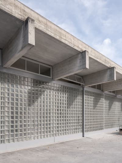 Architectural project - exposed concrete, light grey, industrial facade, modern industrial, low maintenance, concrete facade, robust structure, structural expression, atmospheric light, modernist architecture, glass block, brutalist style, glass block wall, grid texture, utilitarian aesthetic, functional simplicity, reinforced concrete, architectural detail, eco-friendly design, grey tones, industrial design, raw materials, outdoor space, passive design, industrial aesthetic, contemporary architecture, daylight, industrial vibe, exterior design, geometric pattern, simple design, minimalist style, neutral palette, translucent wall, urban design, architecture detail, structural beams, durable materials, sustainable material, sleek design, modern exterior, public building, functional facade, urban facade, industrial modern