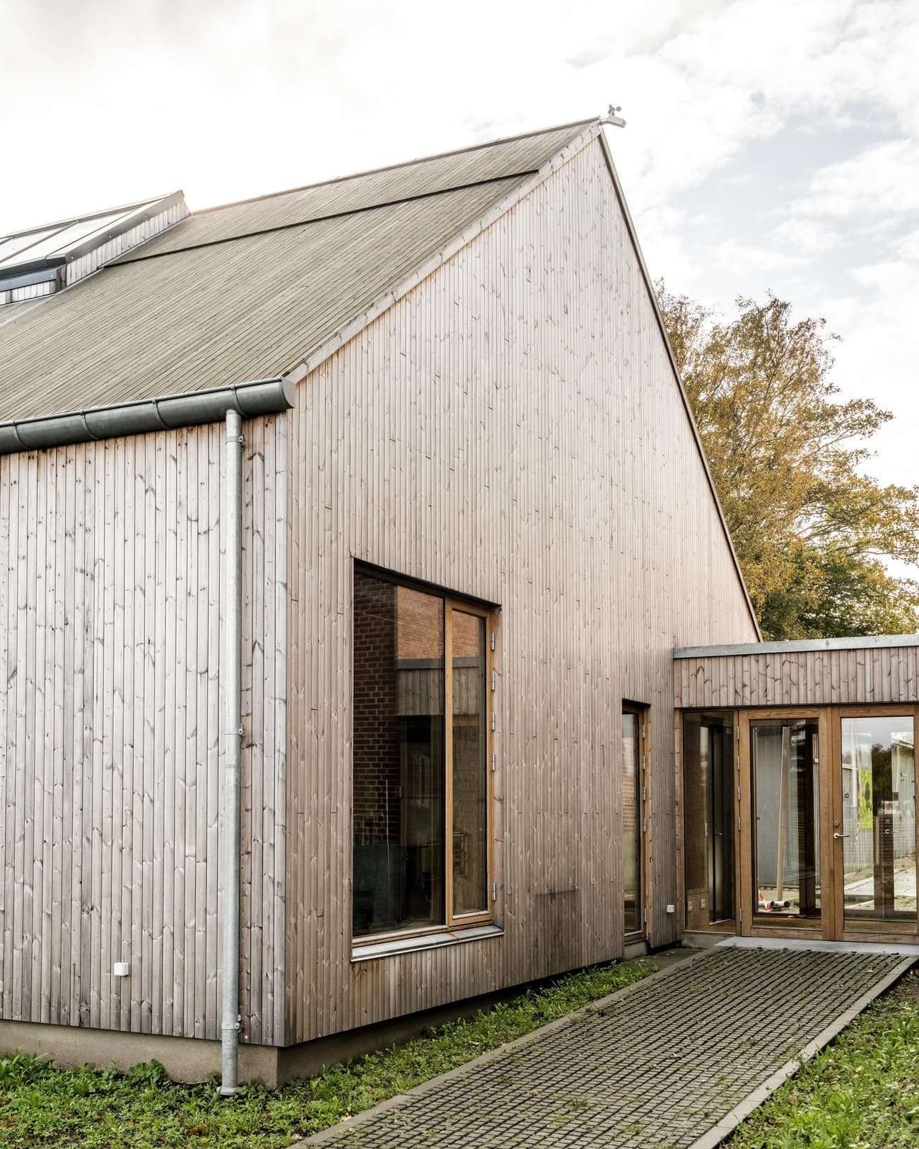 Architectural project - contemporary barn, eco-friendly house, garden setting, wood, timber, natural light, sustainable design, glass, warm tones, sustainable architecture, timber facade, exterior design, light wood, natural wood, wood exterior, airy design, neutral palette, glass doors, green architecture, biophilic design, clean lines, large windows, timber cladding, timber house, Nordic style, countryside home, energy efficient, open plan, wood texture, sloped roof, pitched roof, environmental design, outdoor connection, residential architecture, minimalist exterior, Scandinavian design, modern home, cozy home, vertical cladding, modern rural, simple architecture, natural surroundings, rural house, inviting facade