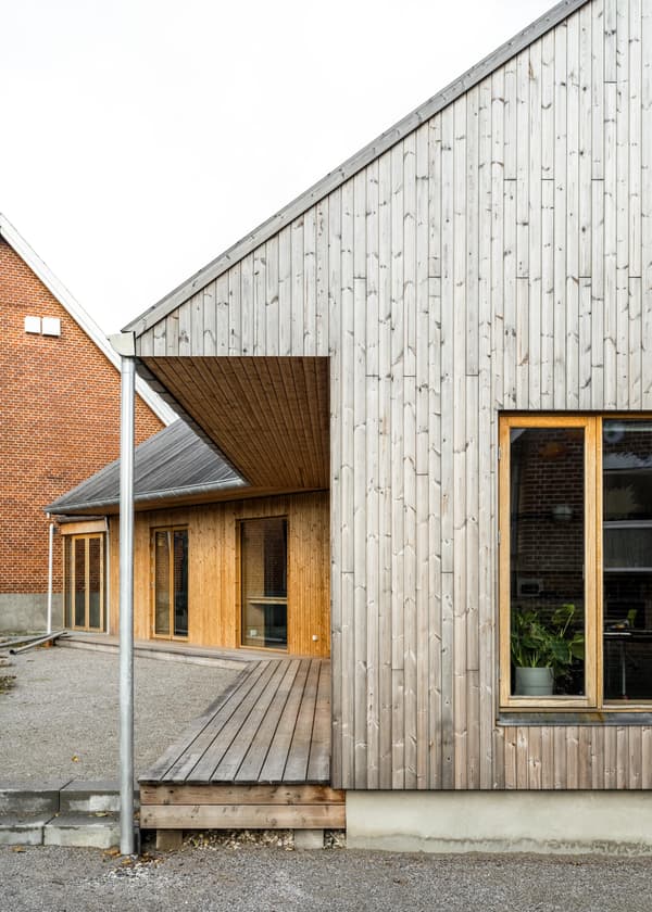 Architectural project - linear design, modern farmhouse, wooden windows, home exterior, wooden terrace, natural materials, wood, timber, outdoor space, natural light, outdoor living, sustainable design, warm tones, contemporary architecture, grey, neutral tones, daylight, beige, brown, wood facade, timber facade, light wood, natural wood, eco friendly, Scandinavian influence, simple design, honey wood, rustic modern, neutral palette, minimalist design, raw wood, passive house, clean lines, timber cladding, wood cladding, Nordic design, countryside home, energy efficient, rustic style, pitched roof, warm texture, rural setting, exterior view, gable roof, cozy exterior, residential building, architectural rhythm, inviting facade