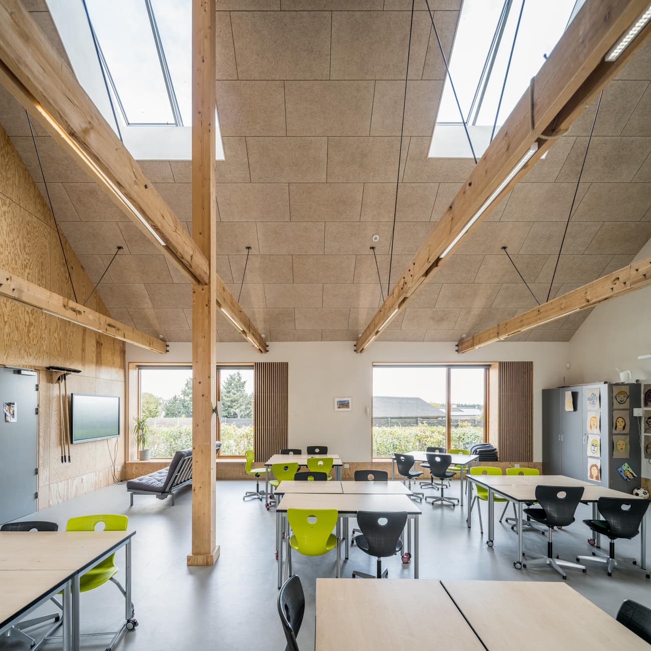 Architectural project - flexible layout, skylights, wood furniture, colorful chairs, educational environment, classroom, modern classroom, modular furniture, cork, ergonomic chairs, warm interior, indoor space, natural materials, timber, raw materials, natural light, inviting atmosphere, sustainable design, sustainable construction, innovative design, grey, green, neutral tones, exposed beams, daylight, plywood, beige, concrete, light wood, eco friendly, timber beams, contemporary design, Scandinavian style, timber walls, low carbon, passive house, natural ventilation, wooden interior, timber ceiling, open plan, nature-inspired, green design, bright space, nordic influence, wood ceiling, educational space, learning space, eco school, informal seating