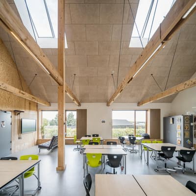 Architectural project - flexible layout, skylights, wood furniture, colorful chairs, educational environment, classroom, modern classroom, modular furniture, cork, ergonomic chairs, warm interior, indoor space, natural materials, timber, raw materials, natural light, inviting atmosphere, sustainable design, sustainable construction, innovative design, grey, green, neutral tones, exposed beams, daylight, plywood, beige, concrete, light wood, eco friendly, timber beams, contemporary design, Scandinavian style, timber walls, low carbon, passive house, natural ventilation, wooden interior, timber ceiling, open plan, nature-inspired, green design, bright space, nordic influence, wood ceiling, educational space, learning space, eco school, informal seating
