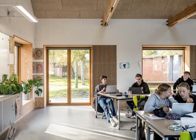 Architectural project - gray, flexible space, cozy environment, gathering spot, timber details, modern classroom, airy ambiance, wood, timber, natural light, passive design, sustainable design, warm tones, natural tones, community space, multifunctional area, neutral tones, daylight, beige, concrete, light wood, contemporary design, Scandinavian style, calming space, relaxed atmosphere, eco-friendly materials, creative space, clean lines, large windows, plaster, open layout, minimalist decor, study area, bright interior, nordic influence, wooden accents, educational space, learning environment, indoor plants, informal seating