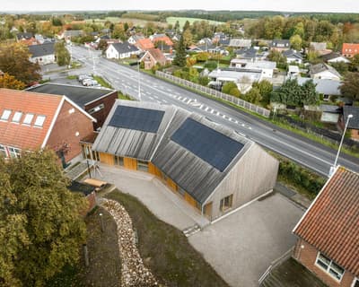 Architectural project - angular roof, natural integration, solar panels, countryside vibe, minimal design, natural materials, wood, timber, eco-conscious, sustainable design, natural tones, eco design, green building, community space, outdoor area, light wood, daylight optimization, contemporary design, low carbon, modern rustic, timber cladding, wood cladding, white, eco friendly home, modern architecture, energy efficient, open layout, pitched roof, rural setting, landscape design, exterior view, wooden facade, inviting exterior, residential building, passive solar, open space, simple lines, aerial view, renewable energy, garden space, environment friendly