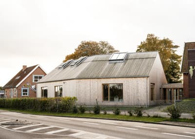Architectural project - light grey, skylights, modern barn, seamless blend, sustainable materials, wood, timber, natural light, glass, warm tones, modular design, eco design, neutral tones, beige, timber facade, daylight optimization, rural architecture, natural textures, rustic charm, Scandinavian style, minimalist design, passive house, natural ventilation, landscape integration, clean lines, timber cladding, wood cladding, Nordic design, eco friendly home, cozy vibe, energy efficient, airy space, open plan, pitched roof, residential design, garden view, gable roof, barn style, warm vibe, eco architecture, wooden facade, spacious home, bright interior, countryside house, sustainable house, family home, simple lines