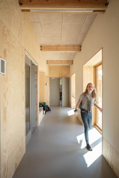 Architectural project - light-filled space, bright corridor, plywood walls, window views, residential corridor, sleek look, minimalistic vibe, sustainable materials, wood, timber, natural light, passive design, warm tones, exposed beams, daylight, beige, light wood, functional design, eco friendly, compact space, simple design, contemporary design, Scandinavian style, neutral palette, minimalist design, timber walls, natural ventilation, clean lines, casual living, inviting space, cozy atmosphere, efficient layout, nordic influence, modern style, wood ceiling, home interior, wood paneling, hallway design