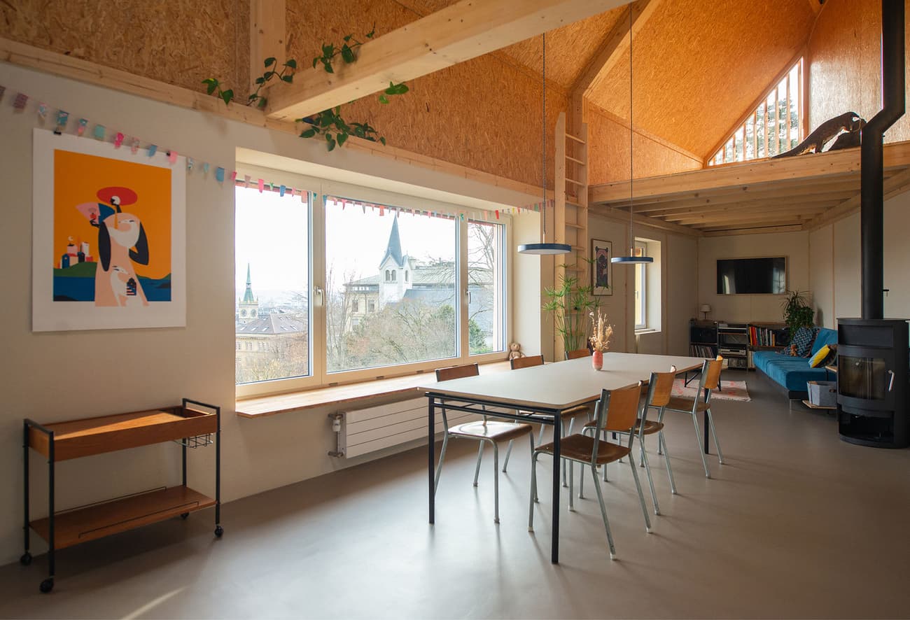 Architectural project - cozy living, vibrant atmosphere, artistic vibe, modern loft, loft apartment, attic space, minimal style, OSB, wooden partition, small apartment, blue sofa, eclectic decor, colorful art, warm interior, natural materials, wood, timber, natural light, sustainable design, pastel colors, warm tones, exposed beams, daylight, wooden ceiling, concrete, light wood, eco friendly, Scandinavian influence, honey wood, industrial touch, multifunctional, cozy space, creative space, large windows, inviting home, Nordic style, wood walls, gallery wall, timber ceiling, compact design, airy space, casual living, open layout, open plan, dining area, dining table, greenery, bright interior, concrete floor, wood flooring, playful space, simple furniture, skylight, indoor plants, high ceiling, urban living