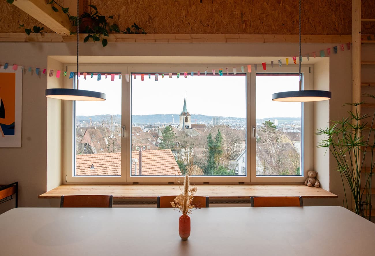 Architectural project - airy interior, home dining, cozy dining, eco interior, Scandinavian touch, house plants, pendant lights, city view, suspended lights, pendant lamps, cottagecore, stylish simplicity, warm interior, natural materials, wood, timber, cityscape, relaxed vibe, natural light, sustainable design, warm tones, exposed structure, contemporary style, daylight, beige, brown, light wood, multifunctional space, modern rustic, scenic view, white, large window, timber ceiling, informal dining, open layout, open plan, dining area, wooden table, dining table, inviting space, minimalist decor, casual dining, simple decor, nordic influence, comfortable living, modern style, wood ceiling, cozy home, simple lines, clean design, picture window, indoor plants, urban view, bright room