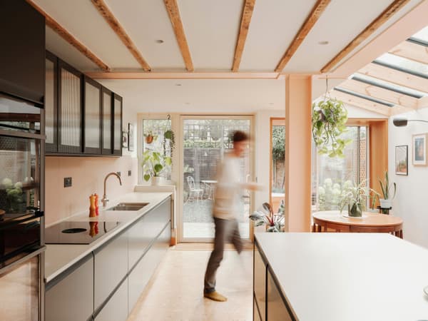 Architectural project - breakfast bar, contemporary kitchen, residential kitchen, reflective surfaces, modern garden, stylish kitchen, sleek cabinetry, black cabinets, warm interior, timber, natural light, sustainable design, glass, warm tones, contemporary style, daylight, beige, light wood, eco friendly, timber beams, neutral palette, minimalist design, black, social space, glass doors, playful elements, biophilic design, sustainable home, indoor outdoor, white, plaster, family kitchen, open layout, open plan, inviting space, casual dining, cozy atmosphere, greenery, garden view, warm vibe, modern kitchen, kitchen island, sliding doors, plaster walls, smooth surfaces, modern interior, skylight, indoor plants