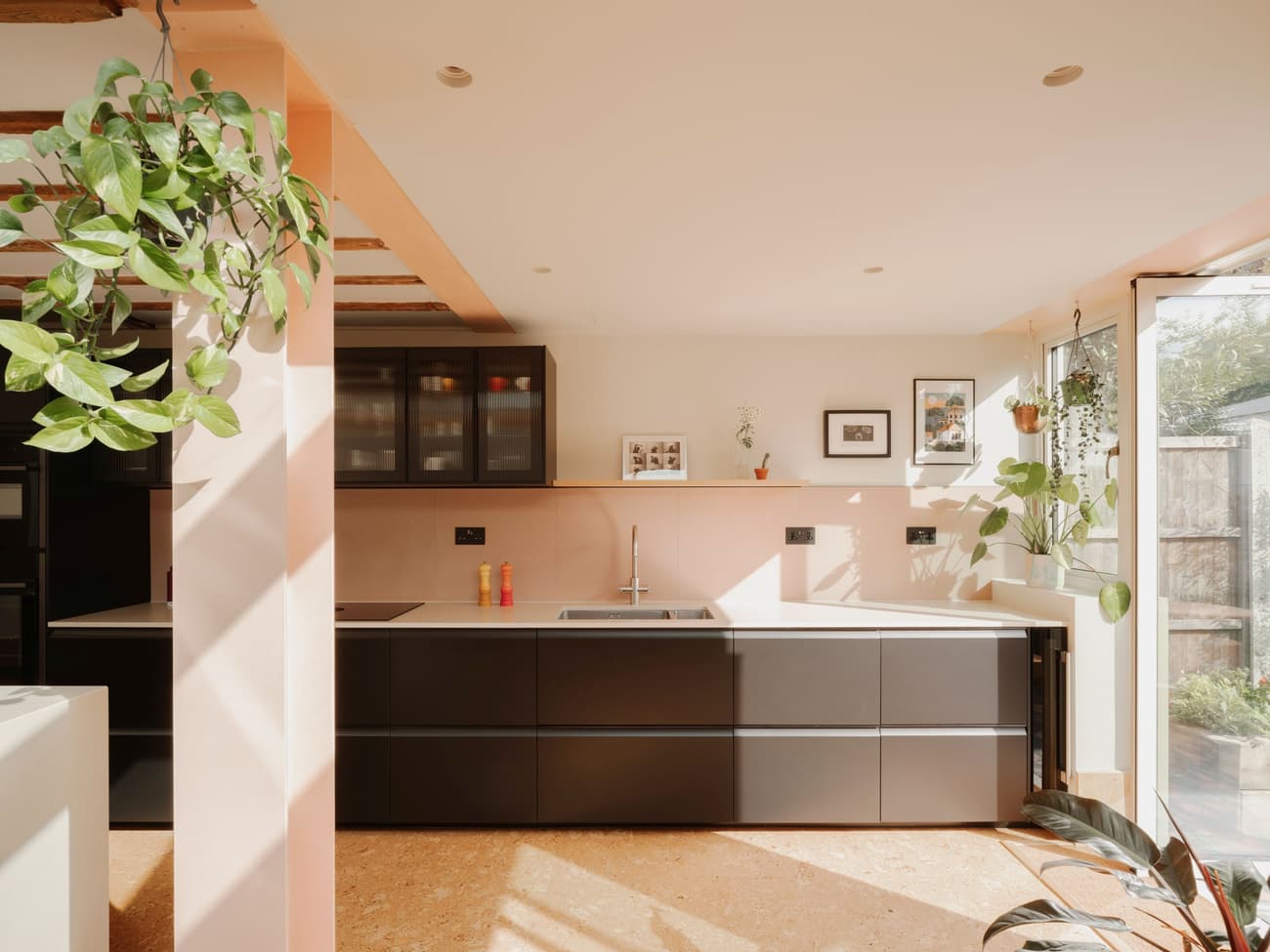Architectural project - contemporary kitchen, pink walls, elegant finish, sleek cabinets, stylish kitchen, speckled floor, terrazzo floor, pastel pink, architectural design, timber, natural light, glass, warm tones, daylight, light wood, modern aesthetic, eco friendly, compact space, black, glass doors, sustainable home, white walls, light filled, indoor outdoor, white, cozy vibe, family kitchen, home kitchen, open layout, open plan, inviting space, greenery, warm vibe, bright interior, minimalist kitchen, modern kitchen, bright space, calm atmosphere, sliding doors, soft tones, functional kitchen, simple style, modern interior, indoor plants, efficient design, urban living