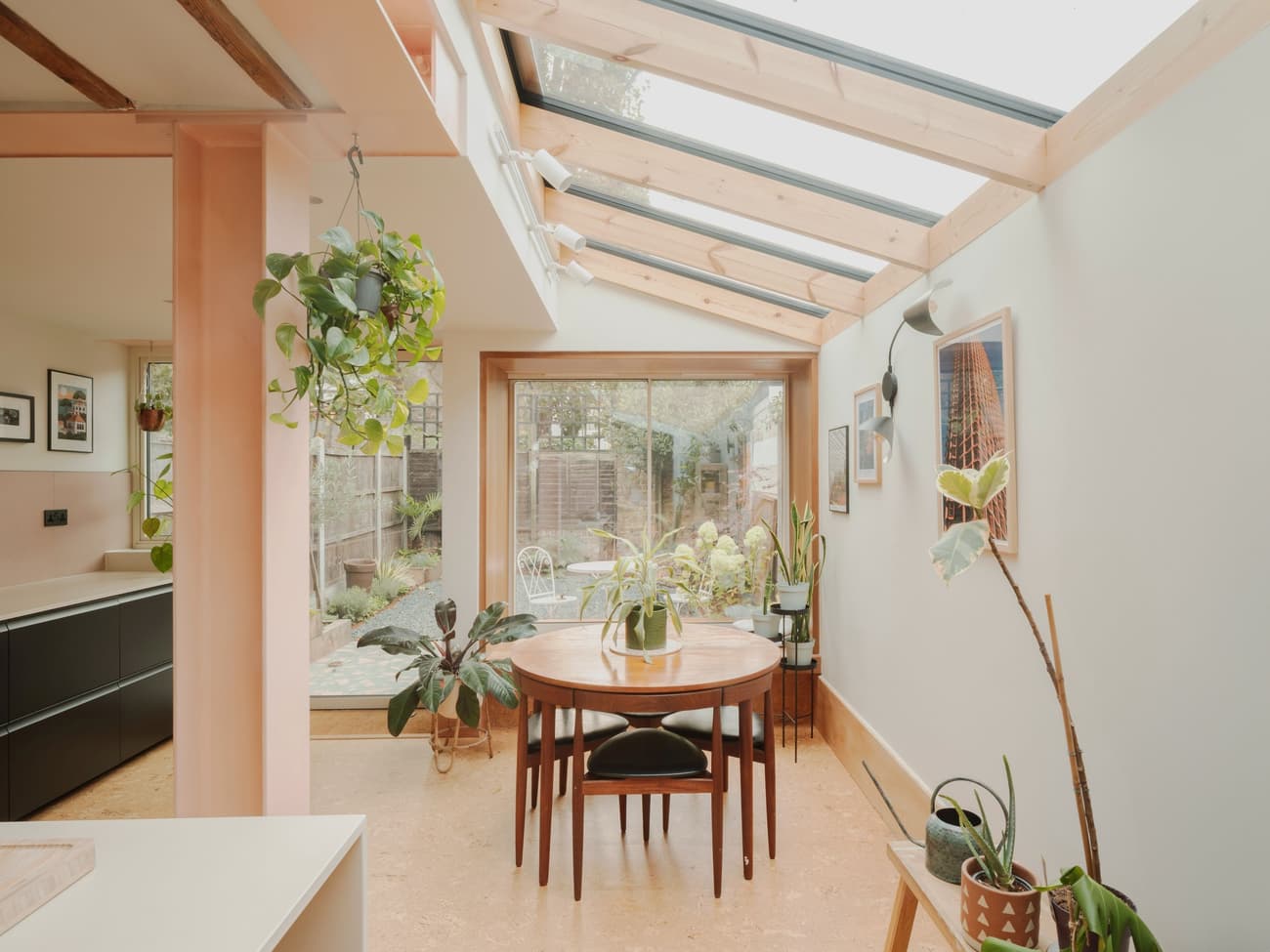 Architectural project - dining room, modern dining, dining chairs, home dining, round table, glass roof, plant decor, Nordic touch, fresh atmosphere, dining nook, cork, pastel pink, wood, natural light, sustainable design, glass, warm tones, eco design, neutral tones, daylight, beige, light wood, Scandinavian influence, simple design, honey wood, timber elements, clean lines, indoor outdoor, white, wood frame, framed art, warm ambiance, relaxed living, open layout, open plan, family space, wooden table, inviting space, minimalist decor, cozy corner, modern style, airy feel, wood panel, casual elegance, skylight, indoor plants, art wall