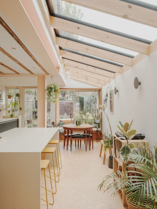 Architectural project - breakfast bar, dining room, wooden chairs, skylight roof, home extension, sunlit space, open dining, cork, natural materials, wood, timber, natural light, inviting atmosphere, sustainable design, glass, warm tones, green, neutral tones, exposed beams, daylight, beige, light wood, low carbon design, honey wood, timber beams, Scandinavian style, neutral palette, glass doors, biophilic design, eco home, cozy vibe, bright kitchen, relaxed living, open layout, open plan, family space, dining area, wooden table, casual dining, nature-inspired, garden view, green design, bright interior, minimal decor, simple lines, airy kitchen, indoor plants