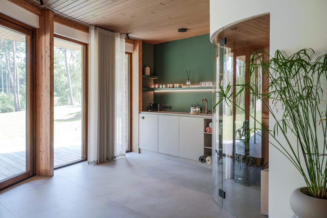 Architectural project - tile, houseplant, patio view, white cabinets, green accent, curtain wall, kitchen corner, curtain detail, light floor, tile floor, relaxation space, soft lighting, serene environment, eco-friendly design, timber, natural light, glass, warm tones, green, functional space, daylight, light wood, simple design, Scandinavian style, neutral palette, glass doors, sustainable home, contemporary home, nature view, clean lines, large windows, indoor outdoor, white, cozy vibe, Nordic style, cozy nook, timber ceiling, home kitchen, casual living, open plan, inviting space, residential design, tranquil vibe, forest view, garden view, minimalist kitchen, modern kitchen, wood ceiling, airy atmosphere, minimal decor, modern interior, indoor plant, green wall