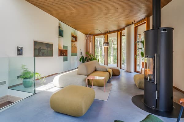 Architectural project - green accents, floor to ceiling windows, living room, wood details, curved ceiling, glass railing, cozy lounge, soft seating, light hardwood, beige furniture, rounded furniture, comfy sofas, black stove, stylish home, wood, timber, natural light, sustainable design, pastel colors, glass, warm tones, contemporary style, green, timber structure, beige, light wood, daylight optimization, eco friendly, Scandinavian style, neutral palette, black, pastel green, biophilic design, clean lines, white walls, large windows, Nordic design, timber ceiling, open layout, minimalist decor, nature-inspired, relaxing space, forest view, modern fireplace, bright interior, calm atmosphere, wood ceiling, family room, wood paneling, modern interior, glass wall, home retreat, indoor plants, urban retreat