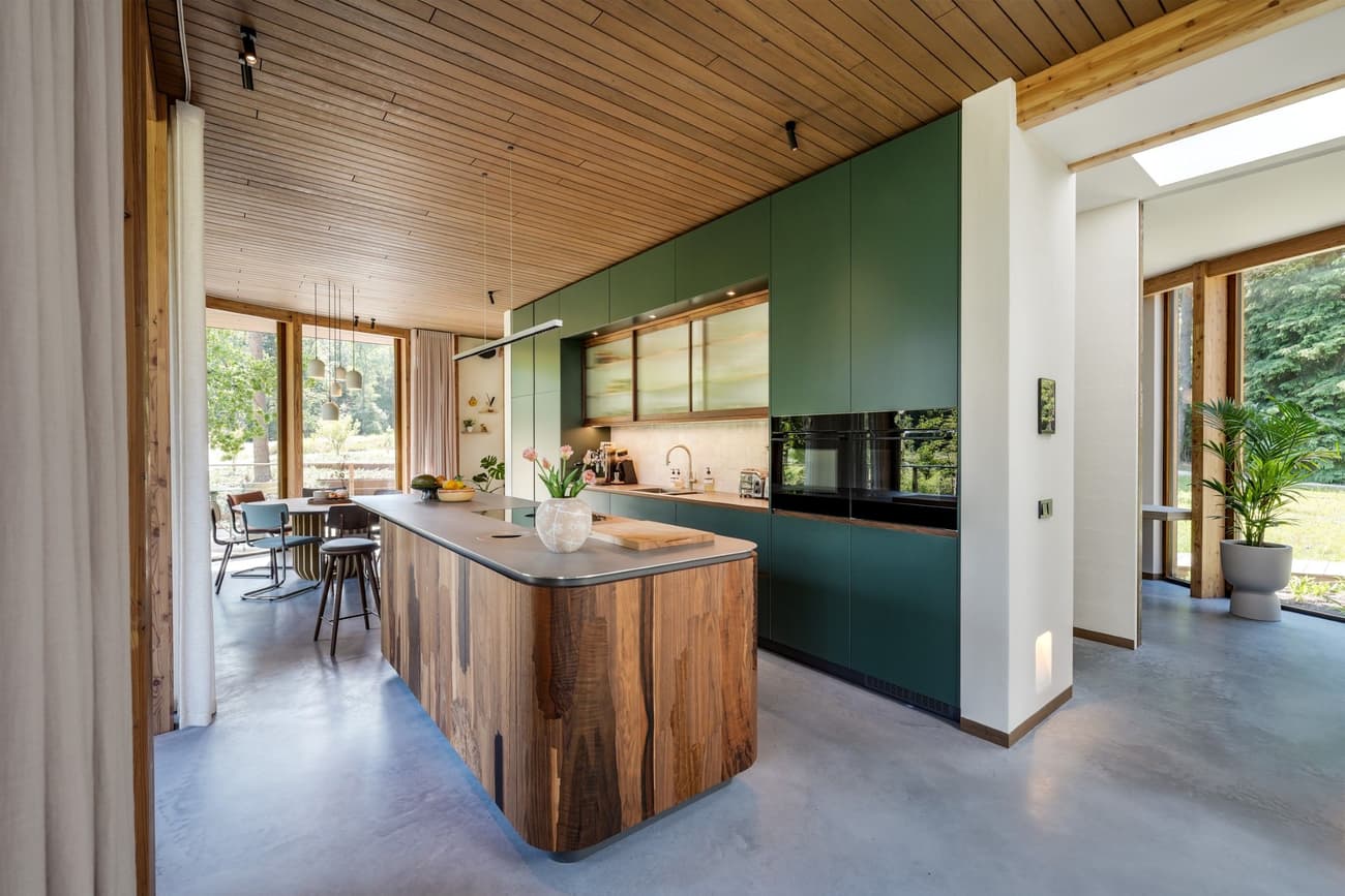 Architectural project - breakfast bar, contemporary kitchen, spacious kitchen, polished concrete, sleek cabinets, stylish home, green kitchen, wooden island, modern appliances, island seating, modern elegance, wood, timber, natural light, sustainable design, green, neutral tones, daylight, wooden ceiling, brown, concrete, light wood, natural wood, blue, natural textures, Scandinavian style, minimalist style, minimalist design, glass doors, wood panels, indoor outdoor, white, eco friendly home, timber ceiling, family kitchen, home kitchen, open layout, open plan, inviting space, earthy tones, casual dining, cozy atmosphere, garden view, warm vibe, Nordic influences, modern home, modern kitchen, kitchen island, concrete floor