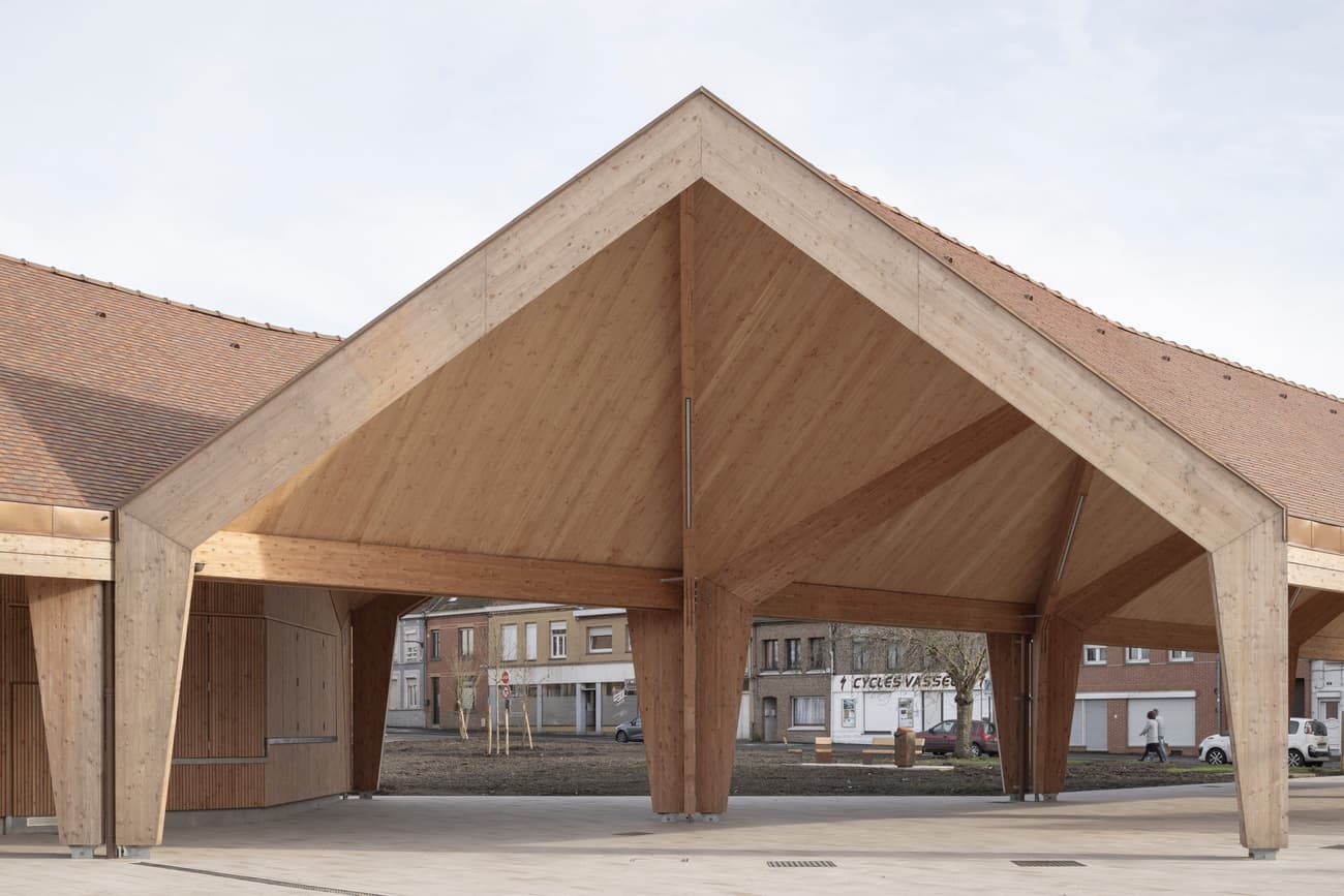 Architectural project - public venue, gathering place, community gathering, urban pavilion, architectural landmark, civic architecture, public pavilion, eco pavilion, natural materials, timber, timber frame, natural light, warm tones, contemporary architecture, timber structure, daylight, beige, brown, roof design, natural wood, modern design, wood beams, rustic modern, wooden pavilion, public space, community center, social hub, outdoor venue, urban design, sustainable structure, geometric design, warm wood, exposed wood, clean lines, timber cladding, inviting space, triangular roof, pavilion design, wooden facade, exterior space, architectural feature