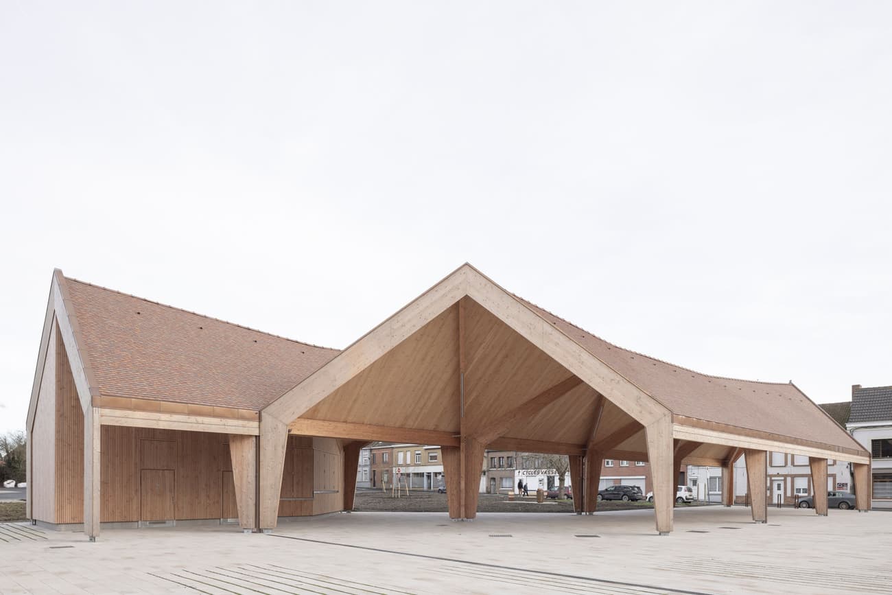Architectural project - angular design, landmark building, public pavilion, natural materials, wood, timber, raw materials, rustic touch, sustainable design, warm tones, eco design, contemporary architecture, neutral tones, timber structure, exposed beams, daylight, gathering space, beige, brown, concrete, light wood, natural wood, wooden beams, sunlight, honey wood, industrial touch, public space, community center, outdoor venue, natural finish, geometric design, minimalist structure, modern pavilion, wood structure, timber cladding, wood cladding, airy space, inviting space, pitched roof, brick, open space, architectural rhythm