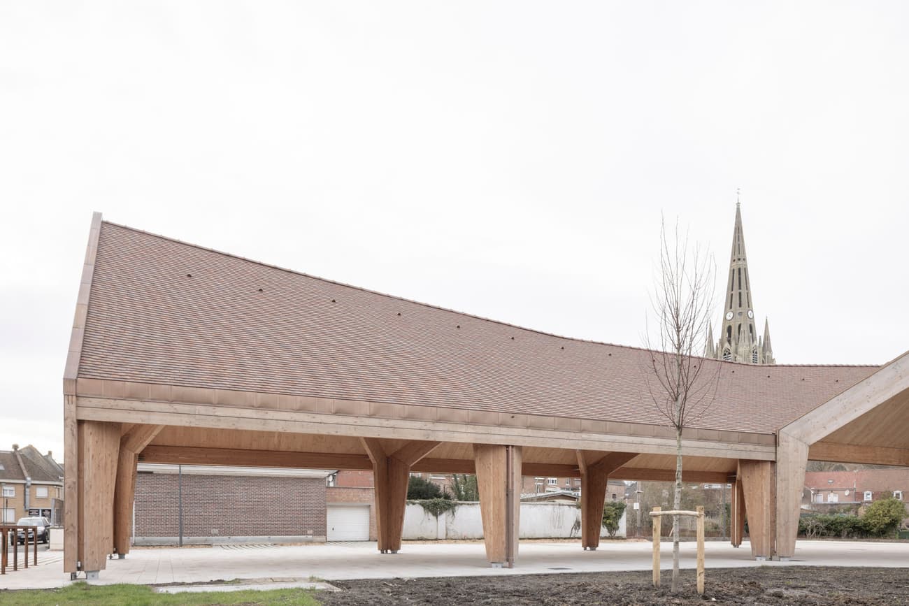 Architectural project - angular roof, welcoming atmosphere, slanted roof, architectural landmark, terracotta roof, public pavilion, natural materials, wood, timber, outdoor space, timber frame, passive design, warm tones, sustainable construction, contemporary architecture, urban landscape, exposed beams, beige, brown, open air design, eco friendly, open structure, wooden beams, natural textures, minimalist design, neutral colors, public space, gathering area, event space, geometric design, modern pavilion, light tones, wood structure, circular design, pitched roof, open pavilion, eco architecture, airy feel, exterior space, clay tiles, tiles, versatile space