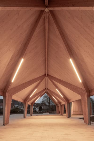 Architectural project - angular design, timber pavilion, architectural landmark, natural materials, soft lighting, eco-friendly design, wood, timber, timber frame, natural light, inviting atmosphere, passive design, warm tones, eco design, community space, engineered timber, neutral tones, daylight, beige, exterior design, light wood, wooden beams, outdoor structure, contemporary design, Scandinavian style, minimalist design, wooden pavilion, public space, gathering area, event space, outdoor venue, wood construction, sustainable structure, modern pavilion, structural wood, timber architecture, green architecture, timber roof, Nordic style, textured wood, open space, warm lighting, vaulted ceiling