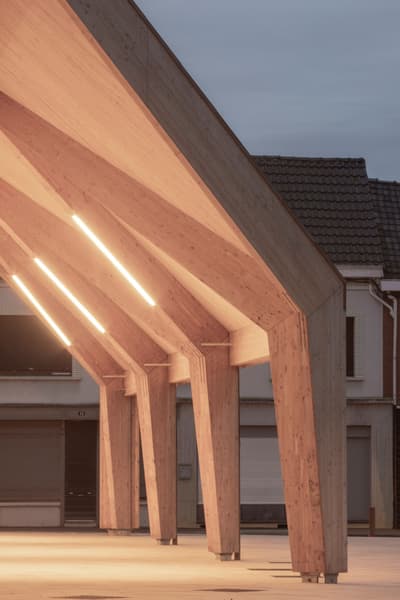 Architectural project - evening setting, exterior lighting, gathering spot, timber pavilion, ambient lighting, town center, wood, timber, outdoor space, warm tones, natural tones, eco design, community space, engineered timber, contemporary style, sustainable architecture, renewable materials, timber structure, public area, light wood, open design, timber construction, minimalist architecture, community hub, outdoor pavilion, social hub, wood construction, urban design, eco-friendly materials, geometric design, CLT, structural beams, modern architecture, pitched roof, warm light, urban context, architectural feature
