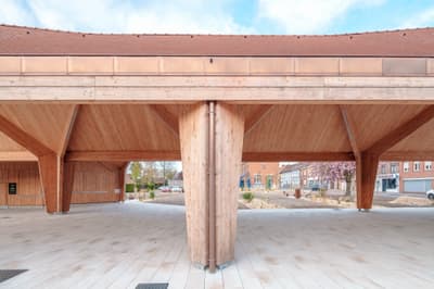 Architectural project - public venue, timber columns, timber pavilion, natural materials, architectural detail, wood, timber, urban setting, outdoor space, timber frame, natural light, sustainable design, warm tones, community space, contemporary architecture, exposed beams, gathering space, light wood, open structure, honey wood, timber beams, rustic modern, natural textures, Scandinavian style, neutral palette, minimalist design, public space, social hub, wood construction, modern pavilion, structural wood, biophilic design, Nordic style, beige tones, inviting space, outdoor shelter, open air, eco architecture, airy atmosphere, wooden columns, light beige