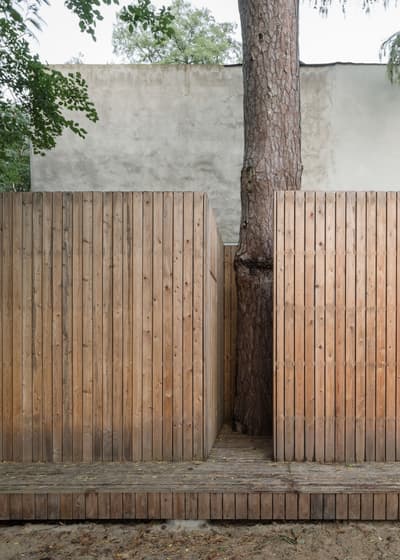 Architectural project - rustic elegance, architectural landmark, built around tree, natural harmony, landscape synergy, wooden path, quiet escape, natural materials, serene environment, eco-friendly design, wood, timber, raw materials, outdoor space, privacy screen, sustainable design, landscape architecture, beige, brown, wood facade, timber facade, exterior design, natural textures, contemporary design, minimalist design, modern rustic, biophilic design, clean lines, earthy tones, nature-inspired, woodland setting, organic architecture, garden design, tree integration, wooden cladding, wooden structure, seamless integration, outdoor retreat, vertical cladding, simple form, exterior cladding
