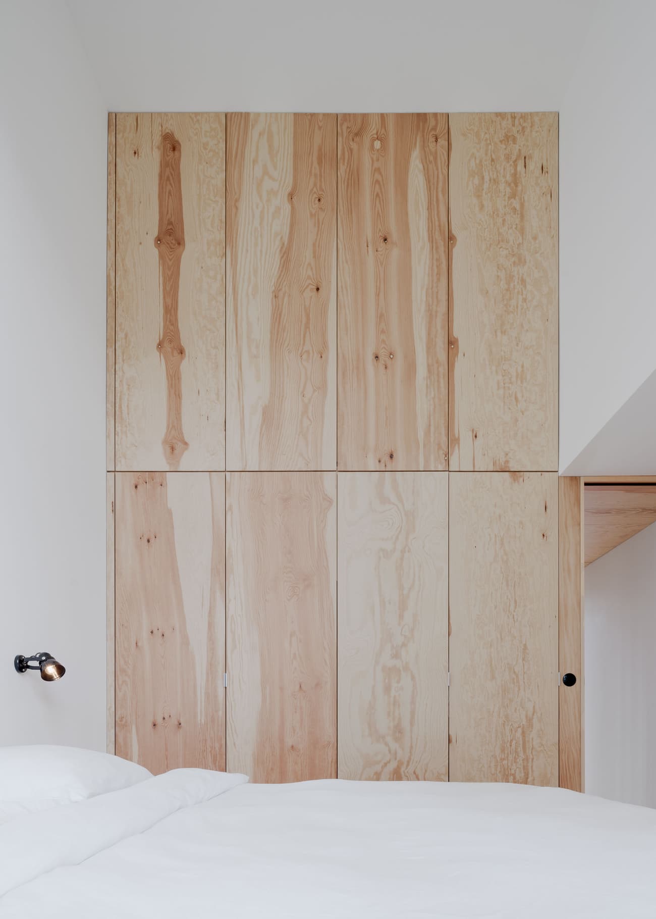 Architectural project - bedroom, wooden wall, white bedding, pared-down, bedroom wall, homely vibe, minimalist, natural materials, tranquil space, serene environment, wood, timber, sustainable design, eco design, contemporary style, neutral tones, functional space, beige, light wood, natural wood, eco friendly, compact space, simple design, calm ambiance, Scandinavian style, neutral palette, minimalist design, neutral colors, soft textures, light tones, modern minimalism, clean lines, white, Nordic design, cozy vibe, inviting space, warm atmosphere, relaxing space, sleek design, bright space, timber wall, wood paneling, timber paneling, clutter-free, understated elegance, cozy bedroom, modern retreat