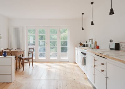 Architectural project - countryside charm, dining room, pendant lighting, white cabinetry, farmhouse table, vintage chairs, homey atmosphere, kitchen dining combo, indoor space, natural materials, wood, timber, raw materials, natural light, warm tones, eco design, neutral tones, daylight, beige, light wood, compact space, simple design, honey wood, Scandinavian style, wooden floor, sustainable home, clean lines, white walls, light filled, large windows, white, cozy vibe, Nordic style, airy space, bright kitchen, comfortable home, relaxed living, open layout, open plan, dining area, inviting space, minimalist decor, family home, minimalist kitchen, glass door, residential, rustic kitchen