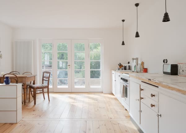 Architectural project - countryside charm, dining room, pendant lighting, white cabinetry, farmhouse table, vintage chairs, homey atmosphere, kitchen dining combo, indoor space, natural materials, wood, timber, raw materials, natural light, warm tones, eco design, neutral tones, daylight, beige, light wood, compact space, simple design, honey wood, Scandinavian style, wooden floor, sustainable home, clean lines, white walls, light filled, large windows, white, cozy vibe, Nordic style, airy space, bright kitchen, comfortable home, relaxed living, open layout, open plan, dining area, inviting space, minimalist decor, family home, minimalist kitchen, glass door, residential, rustic kitchen