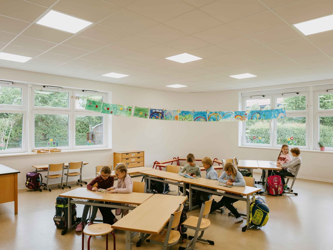 Architectural project - colorful decor, educational environment, classroom, school room, seating arrangement, inspiring space, minimal design, indoor space, sustainable materials, natural light, neutral tones, daylight, beige, light wood, functional design, simple design, interactive space, white walls, white, window view, open layout, warm atmosphere, child friendly, study area, pale wood, educational space, learning space, eco conscious design, school interior, bright room, light flooring