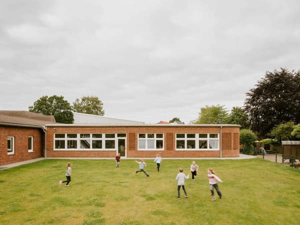 Architectural project - children playing, educational facility, school garden, single story, welcoming environment, glass, community space, outdoor area, green, daylight, multi-use space, beige, functional design, flat roof, community hub, exterior, recreation area, large windows, white, brick, brick facade, red brick, classic architecture, green lawn, open space, educational building, public building, green space, learning environment, outdoor learning, outdoor play, playground, school architecture, play area, family-friendly, brick building, red
