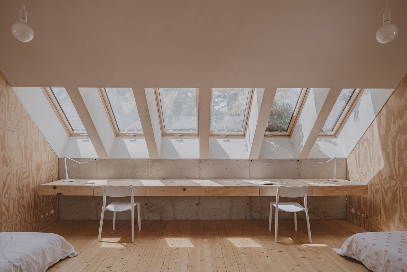 Architectural project - raw aesthetic, inviting vibe, natural materials, timber, natural light, sustainable design, warm tones, contemporary style, neutral tones, plywood, beige, concrete, light wood, daylight optimization, eco friendly, modern design, compact space, serene atmosphere, Scandinavian style, neutral palette, plywood panels, passive house, white walls, Nordic style, wooden interior, wood texture, reading nook, home office, study area, interior space, interior design, clean design, simple furniture, sloped ceiling, skylight, home study, bright room