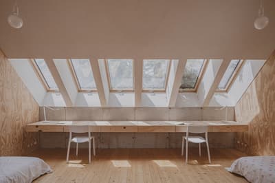 Architectural project - raw aesthetic, inviting vibe, natural materials, timber, natural light, sustainable design, warm tones, contemporary style, neutral tones, plywood, beige, concrete, light wood, daylight optimization, eco friendly, modern design, compact space, serene atmosphere, Scandinavian style, neutral palette, plywood panels, passive house, white walls, Nordic style, wooden interior, wood texture, reading nook, home office, study area, interior space, interior design, clean design, simple furniture, sloped ceiling, skylight, home study, bright room