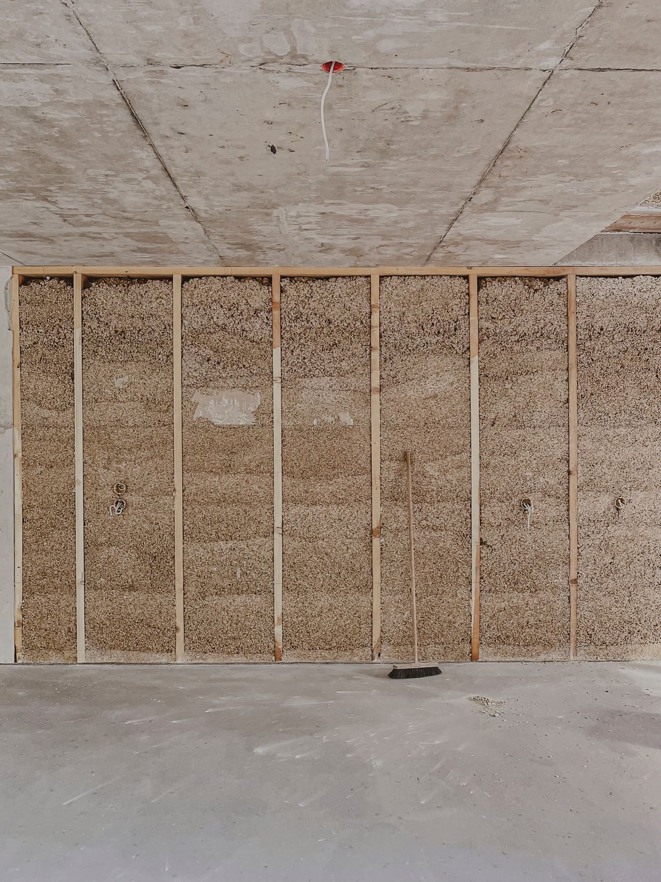Architectural project - straw, resource efficient, unfinished look, raw textures, concrete ceiling, green construction, rough finish, rustic elements, raw space, straw wall, interior construction, natural materials, wood, timber, timber frame, sustainable design, eco design, exposed structure, industrial aesthetic, sustainable architecture, grey, neutral tones, construction phase, construction site, work in progress, construction process, building site, beige, concrete, minimalist construction, natural textures, minimalist vibe, eco materials, eco-friendly materials, sustainable building, durable materials, modern rustic, wood frame, energy efficient, minimal interior, structural elements, straw insulation, straw bale, natural insulation, exposed ceiling