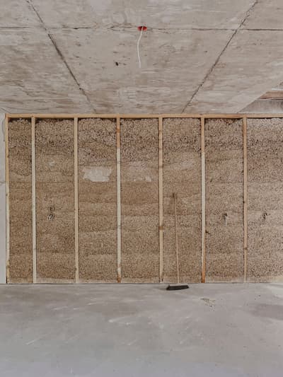 Architectural project - straw, resource efficient, unfinished look, raw textures, concrete ceiling, green construction, rough finish, rustic elements, raw space, straw wall, interior construction, natural materials, wood, timber, timber frame, sustainable design, eco design, exposed structure, industrial aesthetic, sustainable architecture, grey, neutral tones, construction phase, construction site, work in progress, construction process, building site, beige, concrete, minimalist construction, natural textures, minimalist vibe, eco materials, eco-friendly materials, sustainable building, durable materials, modern rustic, wood frame, energy efficient, minimal interior, structural elements, straw insulation, straw bale, natural insulation, exposed ceiling