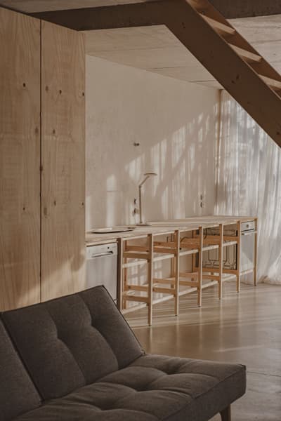 Architectural project - contemporary kitchen, airy interior, wooden chairs, sitting area, home cooking, kitchen nook, open kitchen, timber, casual style, natural light, shadow play, sustainable design, grey, neutral tones, daylight, plywood, beige, light wood, multifunctional space, eco friendly, compact space, simple design, Scandinavian style, neutral palette, minimalist design, clean lines, cozy vibe, Nordic style, textured wall, plaster wall, plaster, relaxed living, timber interior, open plan, dining area, warm atmosphere, functional layout, modern style, plywood interior, muted tones, seamless design, bright room