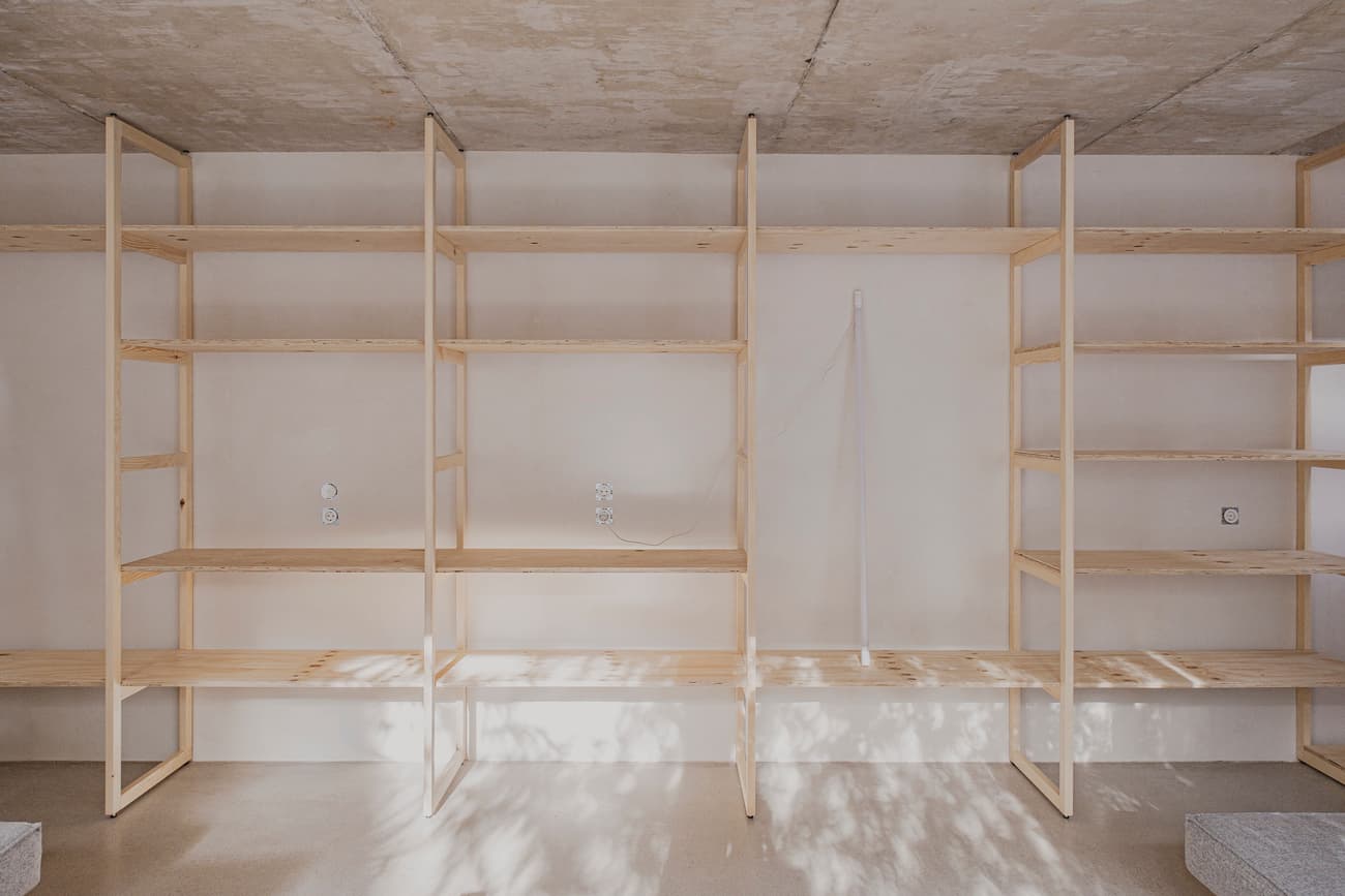 Architectural project - exposed concrete, urban loft, streamlined design, concrete ceiling, functional decor, indoor setting, storage solution, organized living, minimal vibe, sustainable materials, wood, raw materials, shadow play, natural tones, modular design, functional space, plywood, concrete, light wood, natural wood, Scandinavian style, neutral palette, eco-friendly materials, light tones, clean lines, Nordic design, beige tones, open shelves, interior, warm lighting, contemporary space, minimalist shelves, minimalist interior