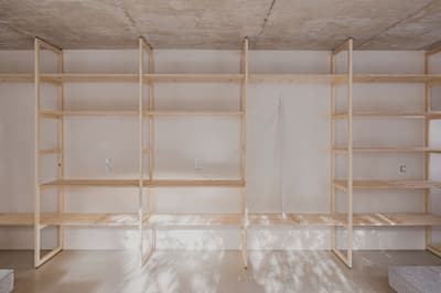 Architectural project - exposed concrete, urban loft, streamlined design, concrete ceiling, functional decor, indoor setting, storage solution, organized living, minimal vibe, sustainable materials, wood, raw materials, shadow play, natural tones, modular design, functional space, plywood, concrete, light wood, natural wood, Scandinavian style, neutral palette, eco-friendly materials, light tones, clean lines, Nordic design, beige tones, open shelves, interior, warm lighting, contemporary space, minimalist shelves, minimalist interior
