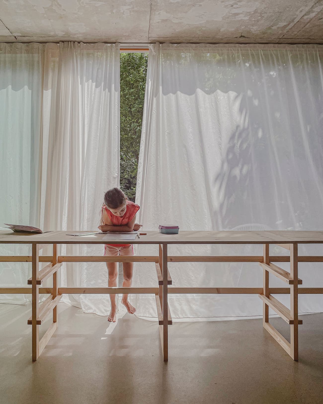 Architectural project - light-filled space, exposed concrete, peaceful environment, home sanctuary, simple table, calm vibe, sheer curtains, airy room, timber furniture, indoor space, timber, natural light, warm tones, eco design, neutral tones, beige, concrete, light wood, multifunctional space, daylight optimization, neutral palette, contemporary interior, minimalist design, serene space, relaxed atmosphere, soft textures, wood structure, sustainable home, natural ventilation, architectural simplicity, white, inviting interior, casual living, open plan, cozy corner, reading nook, home office, study area, concrete floor