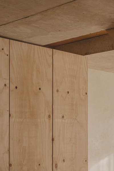 Architectural project - open ceiling, unfinished look, plywood walls, concrete ceiling, understated style, raw interior, modern space, material texture, natural materials, wood, timber, raw materials, relaxed vibe, sustainable design, warm tones, neutral tones, plywood, industrial vibe, concrete, timber detail, industrial style, eco friendly, simple design, architectural texture, calming interior, industrial touch, Scandinavian style, neutral palette, contemporary interior, minimalist design, unfinished interior, modern rustic, clean lines, Nordic style, wood walls, airy space, open plan, inviting space, wood texture, cozy atmosphere, warm vibe, residential space, interior design, airy feel, natural finishes, exposed ceiling