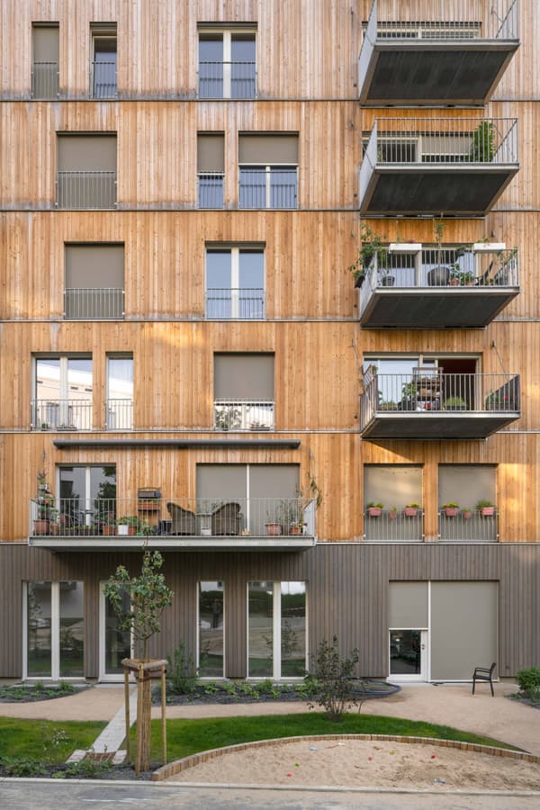 Architectural project - urban greenery, apartment facade, beige facade, potted plants, minimal style, green elements, exterior architecture, community living, natural materials, wood, timber, steel, cityscape, outdoor space, passive design, sustainable design, glass, natural tones, green building, neutral tones, beige, wood facade, timber facade, light wood, daylight optimization, urban oasis, timber construction, natural textures, contemporary design, timber cladding, wood cladding, modern architecture, energy efficient, exterior view, eco-friendly building, raw finish, eco architecture, warm exterior, urban nature, vertical cladding, facade rhythm, residential block, city dwelling, urban living, modern residential, open balconies