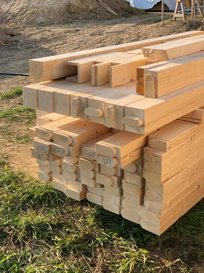Architectural project - natural materials, timber, raw materials, sustainable design, modular construction, eco design, green building, renewable materials, construction site, outdoor construction, construction process, construction materials, construction project, beige, light wood, natural wood, engineered wood, natural setting, wooden beams, timber construction, timber beams, wood construction, eco-friendly materials, wood structure, sustainable building, timber elements, prefab elements, building materials, stacked beams, structural beams, beam joinery, carpentry elements, timber joinery, mass timber, durable materials, ecological design, timber architecture, timber stacking, outdoor building, prefabricated elements, site preparation, woodwork, natural landscape, construction logistics