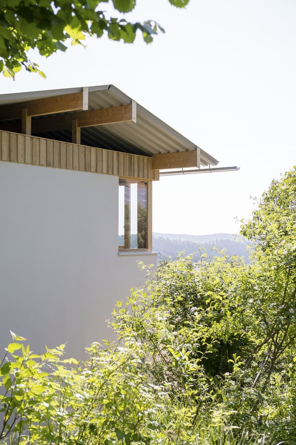 Architectural project - wood, timber, grey, metal, natural light, outdoor living, modular construction, eco design, timber structure, green, structural timber, beige, minimalist facade, open air design, low carbon design, daylight optimization, timber construction, rural architecture, minimalist design, wood construction, eco-friendly materials, plywood panels, prefabricated elements, biophilic design, eco home, sustainable home, passive house, natural ventilation, contemporary home, modern facade, timber roof, wood roofing, metal roof, corrugated metal, hillside house, nature view, scenic view, landscape integration, rural design, modern minimalism, clean lines, white facade, white walls, green landscape, airy architecture, light filled, large windows, window wall, energy efficient design, nature connectedness, outside in, indoor outdoor, wood framing, timber cladding, wood cladding, architectural simplicity, elegant design, simple elegance, bright exterior, white